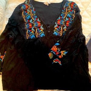 Black blouse with jewel tone embroidery detail.